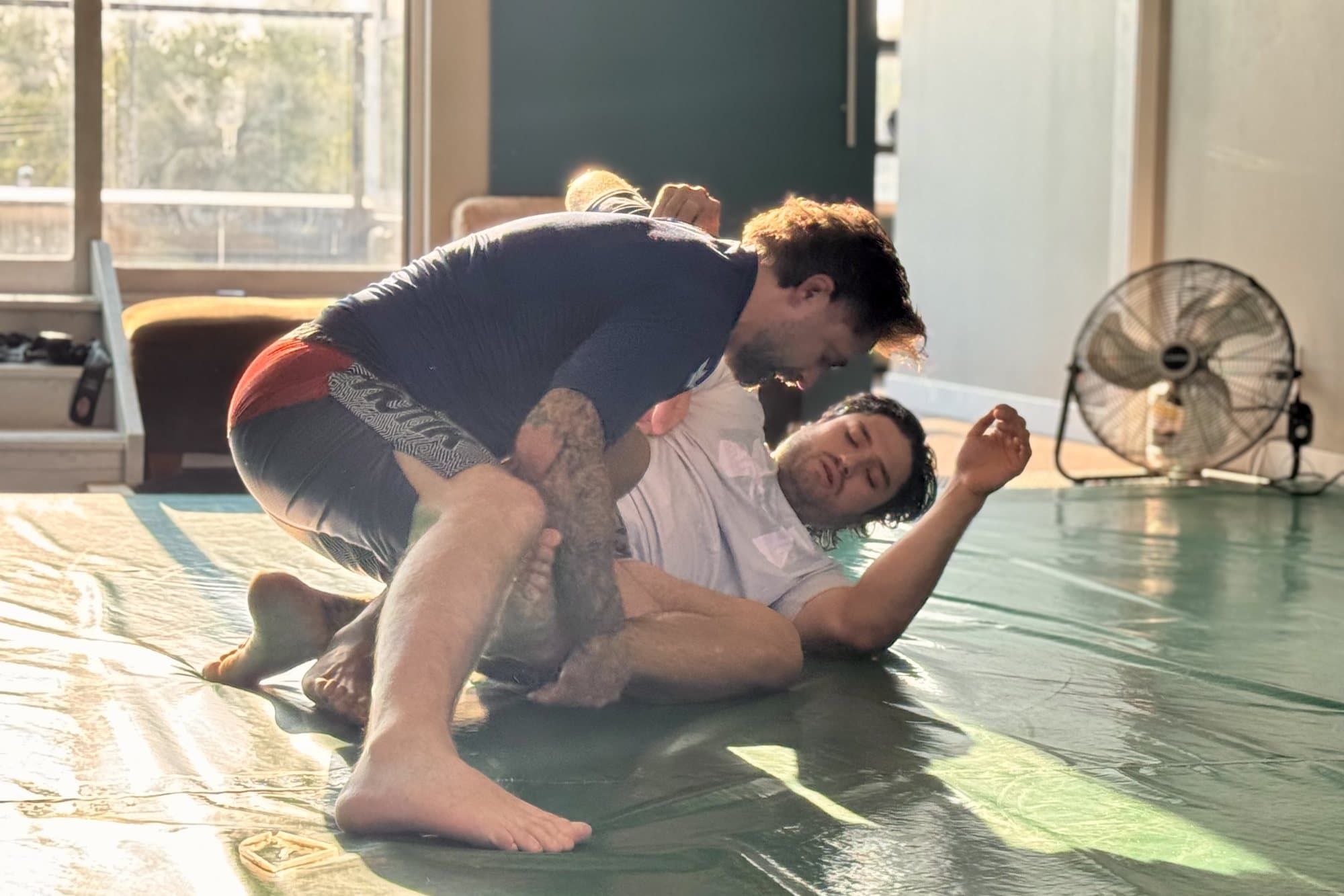 Two students working a guard pass during a Brazilian Jiu-Jitsu class in Calgary