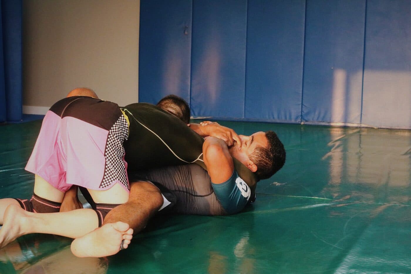 Two students rolling during a Brazilian Jiu-Jitsu class at Wiley Jiu-Jitsu YYC in Calgary