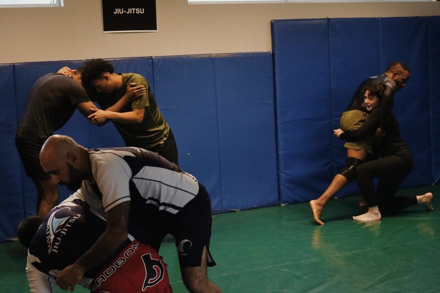 Instructor demonstrating a fundamental Brazilian Jiu-Jitsu position to a beginner in Calgary